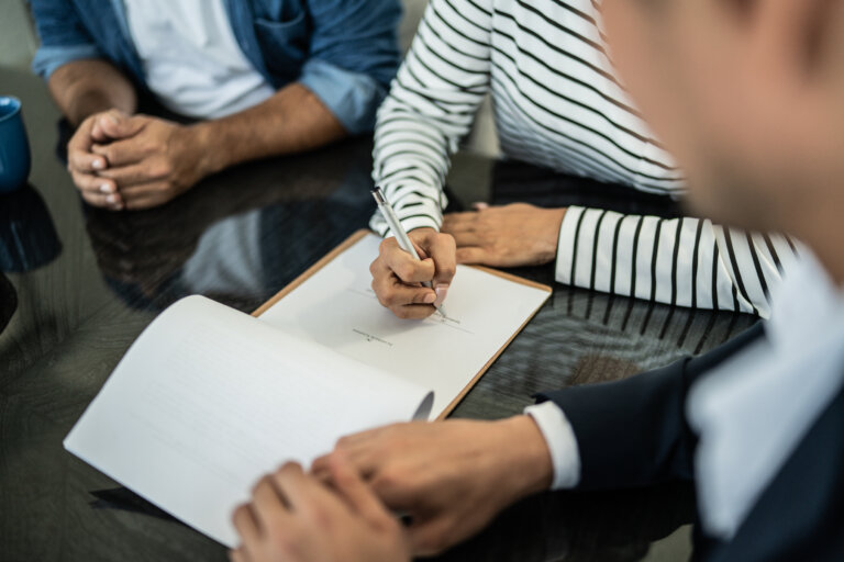 Close-up of hand filling paperwork at home